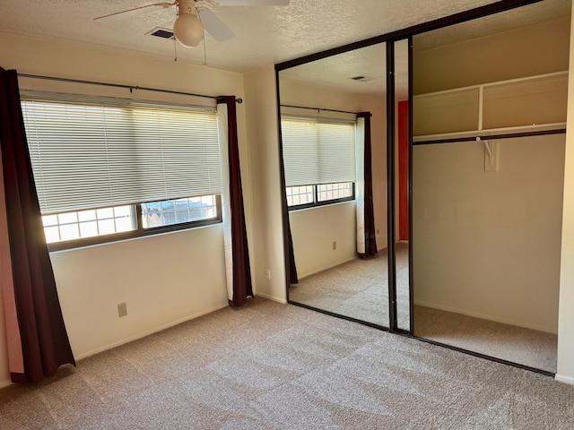 774 Stallion Rd SE, Rio Rancho, NM 87124 - unfurnished bedroom with light colored carpet, a textured ceiling, multiple windows, and a closet