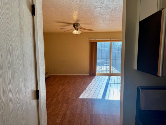 774 Stallion Rd SE, Rio Rancho, NM 87124 - unfurnished room featuring a ceiling fan, a textured ceiling, wood finished floors, and baseboards