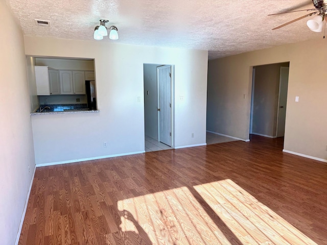 774 Stallion Rd SE, Rio Rancho, NM 87124 - empty room featuring a ceiling fan, wood finished floors, a textured ceiling, and baseboards