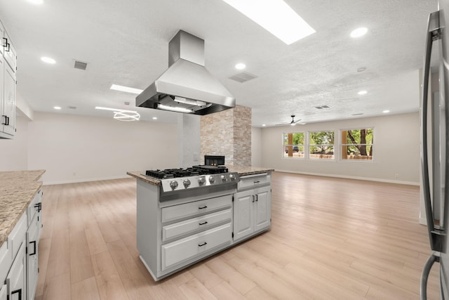 697 W Meadowlark Ln, Corrales, NM 87048 - kitchen with island range hood, open floor plan, stainless steel gas stovetop, baseboards, and recessed lighting