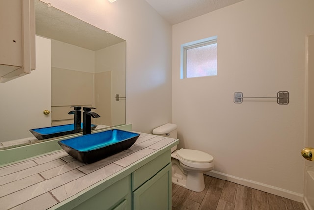 3742 Cattle Dr, Rio Rancho, NM 87144 - bathroom featuring vanity, toilet, wood finished floors, and baseboards