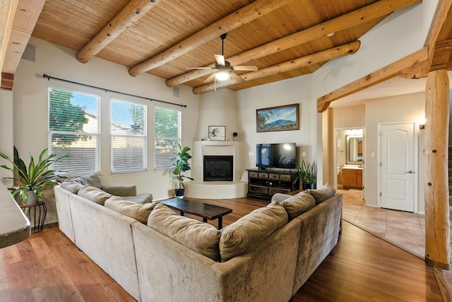 2004 Rancho Oro Ave SE, Rio Rancho, NM 87124 - living area featuring a wood ceiling with exposed beams, ceiling fan, a large fireplace, and light wood-style floors