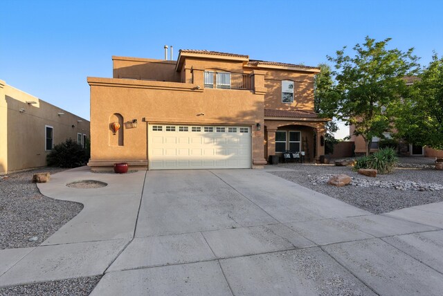 2004 Rancho Oro Ave SE, Rio Rancho, NM 87124 - view of front of home featuring a balcony, concrete driveway, stucco siding, and a tiled roof