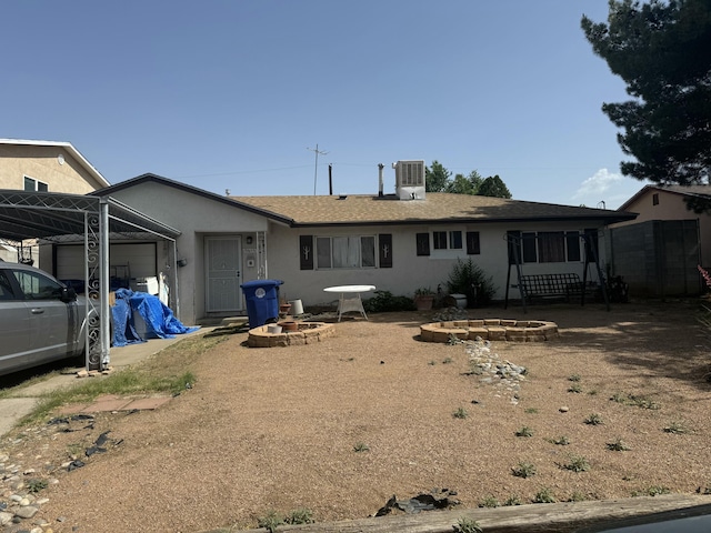 9613 Hannett Ave NE, Albuquerque, NM 87112 - rear view of house with stucco siding, a garage, an outdoor fire pit, and central AC unit
