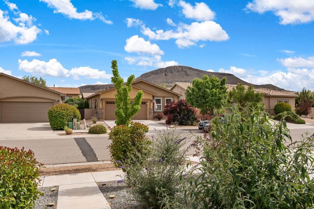 240 Rio Chama Cir SW, Los Lunas, NM 87031 - view of front of house featuring stucco siding, a mountain view, an attached garage, and concrete driveway