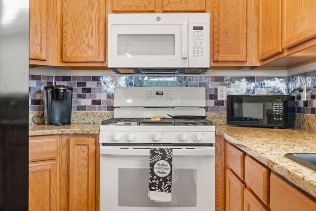 240 Rio Chama Cir SW, Los Lunas, NM 87031 - kitchen with white appliances, decorative backsplash, and light stone countertops