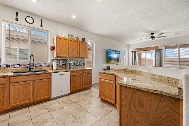 240 Rio Chama Cir SW, Los Lunas, NM 87031 - kitchen with white dishwasher, a sink, backsplash, ceiling fan, and a textured ceiling