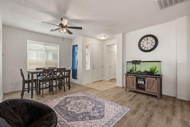 240 Rio Chama Cir SW, Los Lunas, NM 87031 - dining room featuring a ceiling fan, light wood finished floors, a textured ceiling, and baseboards