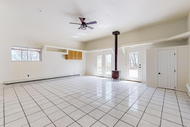 41 El Rancho Grande Rd, Mcintosh, NM 87032 - unfurnished living room with a baseboard heating unit, a wood stove, ceiling fan, and light tile patterned floors