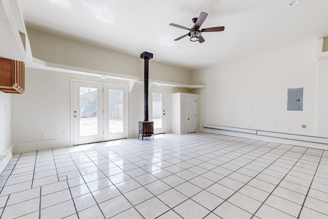 41 El Rancho Grande Rd, Mcintosh, NM 87032 - unfurnished living room featuring a wood stove, electric panel, a baseboard heating unit, ceiling fan, and light tile patterned floors