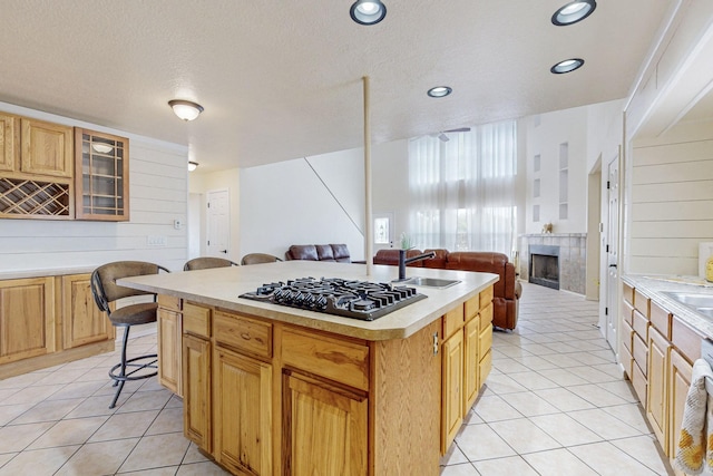 41 El Rancho Grande Rd, Mcintosh, NM 87032 - kitchen featuring gas stovetop, open floor plan, a tiled fireplace, light tile patterned floors, and recessed lighting