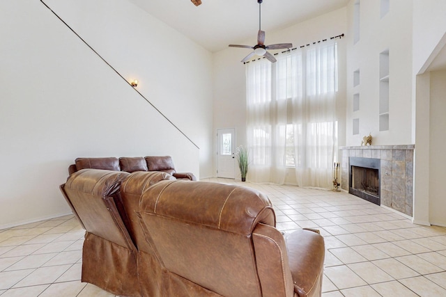 41 El Rancho Grande Rd, Mcintosh, NM 87032 - living area featuring light tile patterned floors, a towering ceiling, ceiling fan, a tiled fireplace, and built in shelves