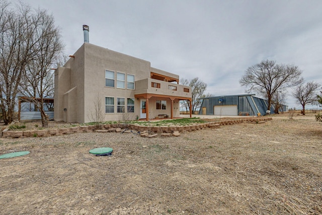 41 El Rancho Grande Rd, Mcintosh, NM 87032 - back of house with an outbuilding, stucco siding, a balcony, and a garage