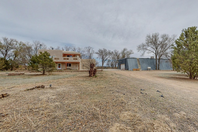 41 El Rancho Grande Rd, Mcintosh, NM 87032 - view of front of property featuring an outdoor structure, an outbuilding, stucco siding, driveway, and a garage