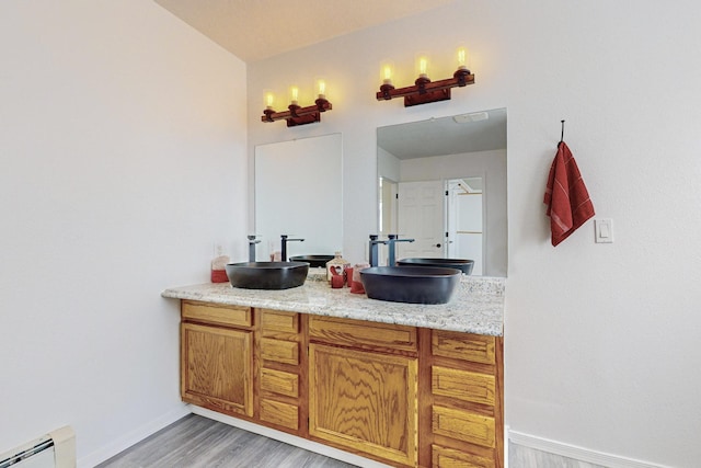 41 El Rancho Grande Rd, Mcintosh, NM 87032 - bathroom featuring baseboard heating, double vanity, and wood finished floors