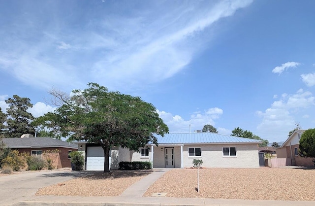 2824 Texas St NE, Albuquerque, NM 87110 - ranch-style home featuring driveway, an attached garage, metal roof, and brick siding