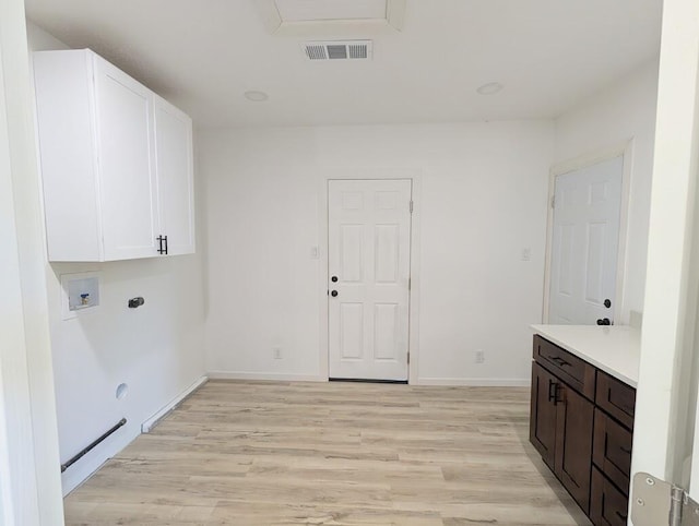 2824 Texas St NE, Albuquerque, NM 87110 - laundry area featuring cabinet space, hookup for a washing machine, light wood finished floors, hookup for an electric dryer, and baseboards