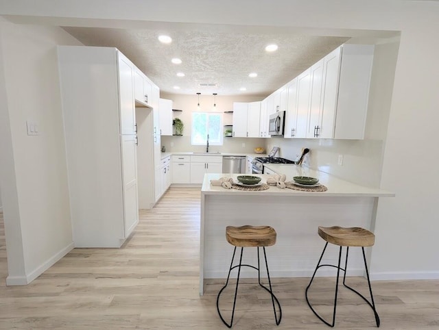 2824 Texas St NE, Albuquerque, NM 87110 - kitchen with a peninsula, appliances with stainless steel finishes, a sink, recessed lighting, and baseboards