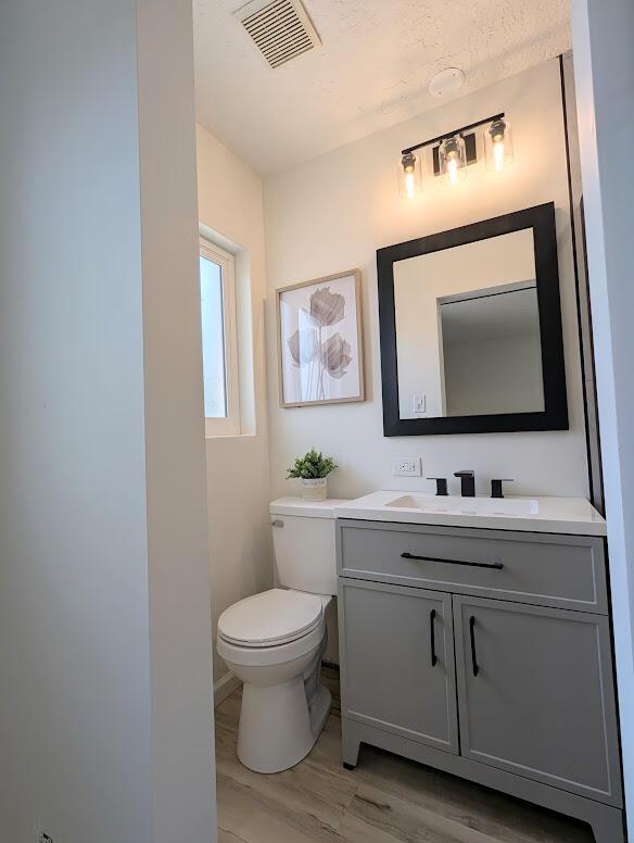 2824 Texas St NE, Albuquerque, NM 87110 - half bath with toilet, vanity, and wood finished floors