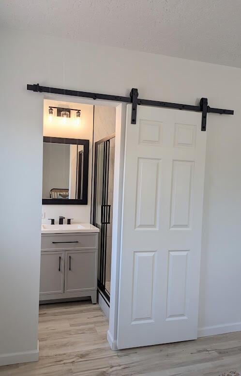 2824 Texas St NE, Albuquerque, NM 87110 - full bathroom featuring vanity, wood finished floors, a stall shower, and a textured ceiling