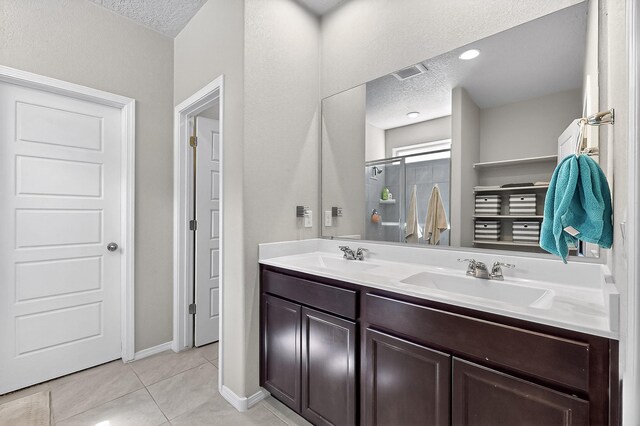 4871 Longs Peak Rd NE, Rio Rancho, NM 87144 - bathroom with a textured ceiling, double vanity, tile patterned floors, an enclosed shower, and baseboards