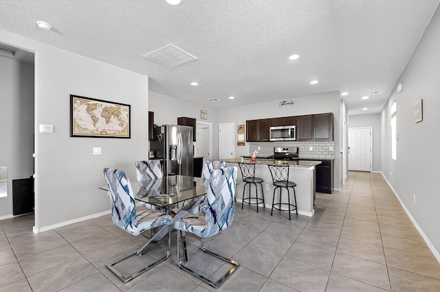 4871 Longs Peak Rd NE, Rio Rancho, NM 87144 - dining room featuring light tile patterned floors, recessed lighting, a textured ceiling, and baseboards