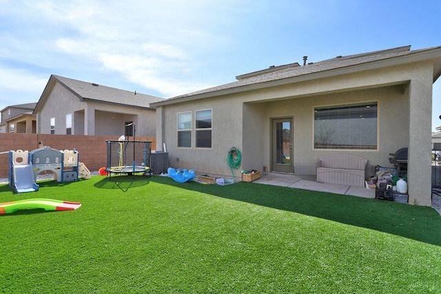 4871 Longs Peak Rd NE, Rio Rancho, NM 87144 - back of property with a trampoline, a playground, stucco siding, and central air condition unit
