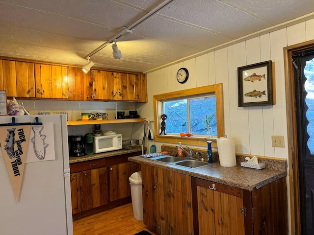 123 Pine Dr, Jemez Springs, NM 87025 - kitchen featuring white appliances, a sink, light wood-style flooring, brown cabinets, and a textured ceiling