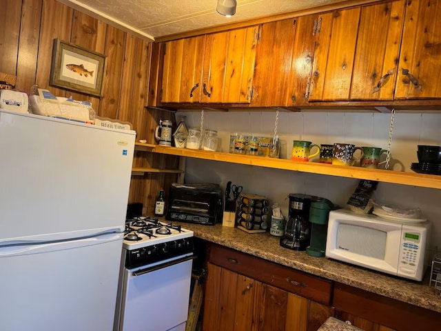 123 Pine Dr, Jemez Springs, NM 87025 - kitchen featuring white appliances, brown cabinetry, and open shelves