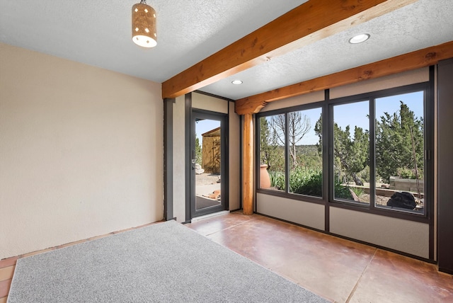 98 Edgewood Unit 7, Edgewood, NM 87015 - empty room featuring a textured ceiling, beam ceiling, concrete flooring, and recessed lighting