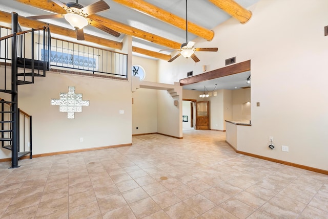98 Edgewood Unit 7, Edgewood, NM 87015 - unfurnished living room featuring a ceiling fan, stairway, a chandelier, beam ceiling, and a high ceiling