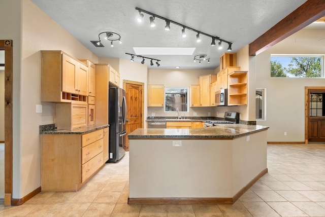 98 Edgewood Unit 7, Edgewood, NM 87015 - kitchen featuring stainless steel appliances, open shelves, a peninsula, dark stone countertops, and light brown cabinetry