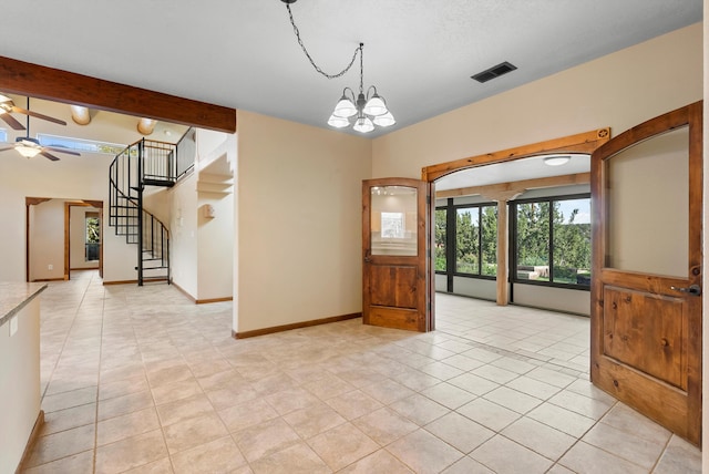 98 Edgewood Unit 7, Edgewood, NM 87015 - unfurnished room featuring a ceiling fan, light tile patterned flooring, stairs, beam ceiling, and a chandelier
