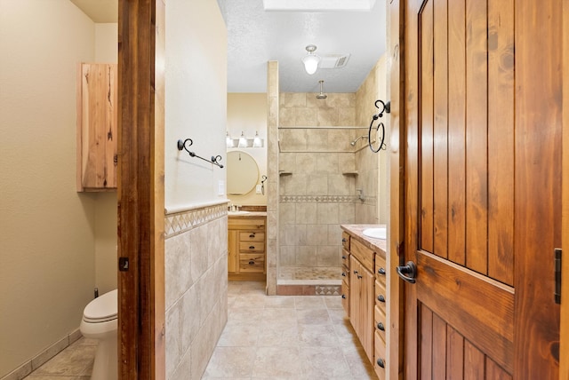 98 Edgewood Unit 7, Edgewood, NM 87015 - bathroom with vanity, a stall shower, tile patterned flooring, and tile walls