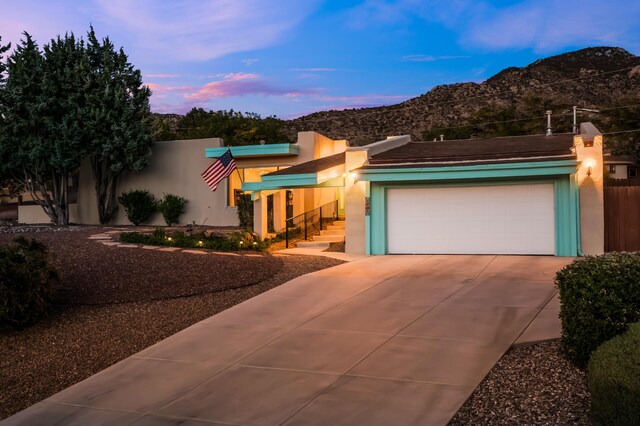 4706 Glenwood Hills Dr NE, Albuquerque, NM 87111 - view of front of house with a mountain view, stucco siding, driveway, and an attached garage