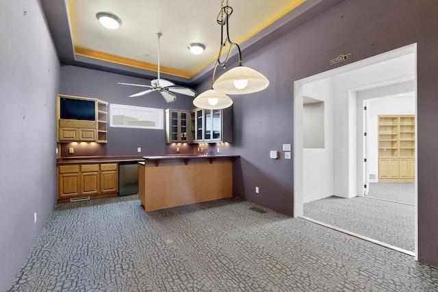 2600 Griegos Pl NW, Albuquerque, NM 87107 - kitchen featuring carpet flooring, a tray ceiling, ceiling fan, dark countertops, and pendant lighting