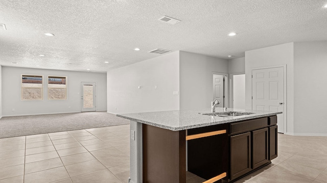 1660 Maggie Dr, Rio Rancho, NM 87144 - kitchen with a sink, light carpet, a textured ceiling, an island with sink, and open floor plan