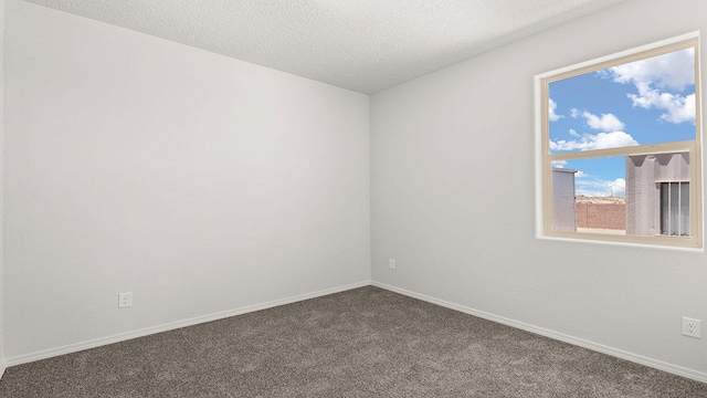 1660 Maggie Dr, Rio Rancho, NM 87144 - empty room with dark carpet, baseboards, and a textured ceiling
