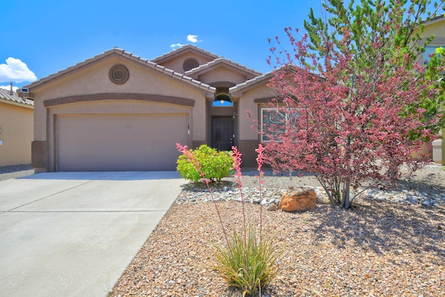 7217 Skagway Dr NE, Rio Rancho, NM 87144 - mediterranean / spanish house featuring stucco siding, a garage, concrete driveway, and a tile roof
