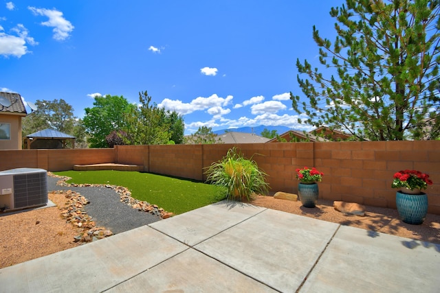 7217 Skagway Dr NE, Rio Rancho, NM 87144 - fenced backyard featuring cooling unit, a patio area, and a mountain view