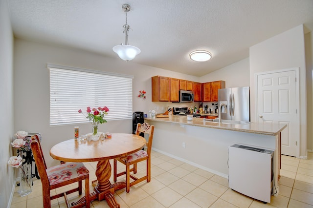 7217 Skagway Dr NE, Rio Rancho, NM 87144 - kitchen featuring appliances with stainless steel finishes, a peninsula, light countertops, brown cabinets, and pendant lighting