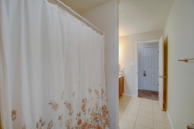 7217 Skagway Dr NE, Rio Rancho, NM 87144 - full bath with a textured ceiling, tile patterned floors, vanity, a shower with curtain, and baseboards