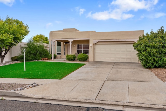 3424 Calle Suenos SE, Rio Rancho, NM 87124 - pueblo-style house with concrete driveway, a garage, stucco siding, and a front lawn