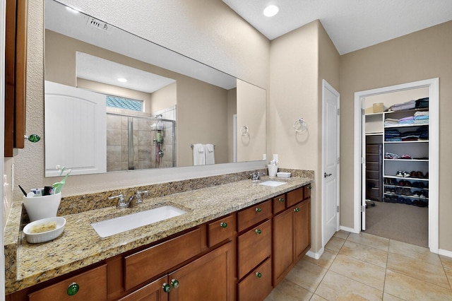 2927 Kings Canyon Loop NE, Rio Rancho, NM 87144 - full bathroom featuring a stall shower, double vanity, tile patterned flooring, a walk in closet, and baseboards