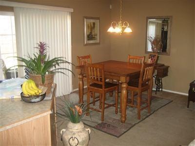4608 Stafford Pl NW, Albuquerque, NM 87120 - carpeted dining room with baseboards and a chandelier