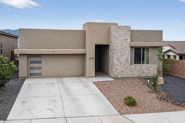6854 Cleary Loop NE, Rio Rancho, NM 87144 - pueblo revival-style home with concrete driveway, an attached garage, and stucco siding