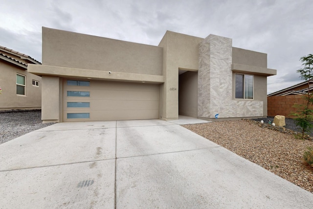 6854 Cleary Loop NE, Rio Rancho, NM 87144 - pueblo-style house with driveway, an attached garage, and stucco siding
