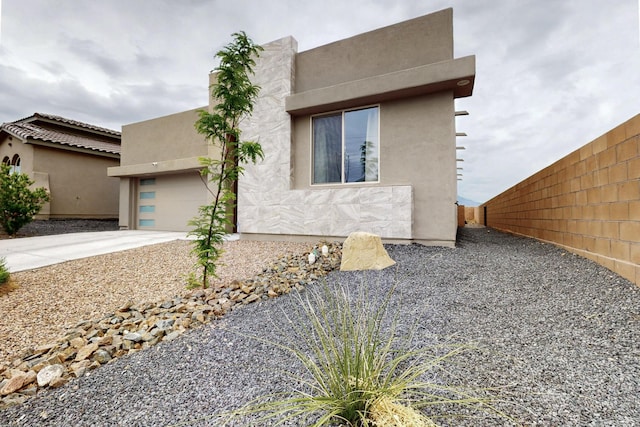 6854 Cleary Loop NE, Rio Rancho, NM 87144 - view of side of property featuring an attached garage, concrete driveway, and stucco siding