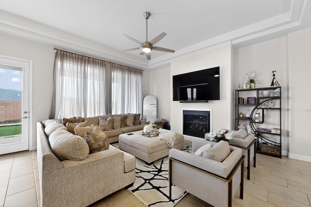 6854 Cleary Loop NE, Rio Rancho, NM 87144 - living room featuring a raised ceiling, a ceiling fan, a glass covered fireplace, and plenty of natural light