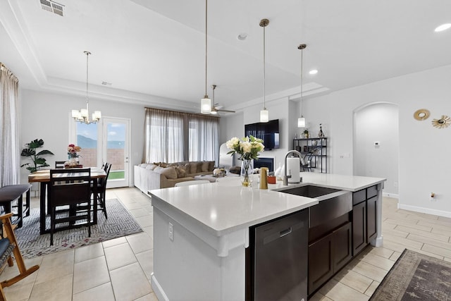 6854 Cleary Loop NE, Rio Rancho, NM 87144 - kitchen with dishwasher, a tray ceiling, arched walkways, light countertops, and open floor plan